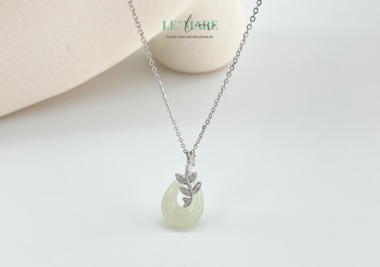 Ngọc Nhu không chỉ là dây chuyền nữ, mà là một câu chuyện được kể bằng ngọc và bạc: một nhành dây leo được tạo hình uyển chuyển ôm lấy viên ngọc bích tròn đầy, như thể đang bảo vệ một trái tim xanh dịu mát khỏi mọi xô bồ cuộc sống.
