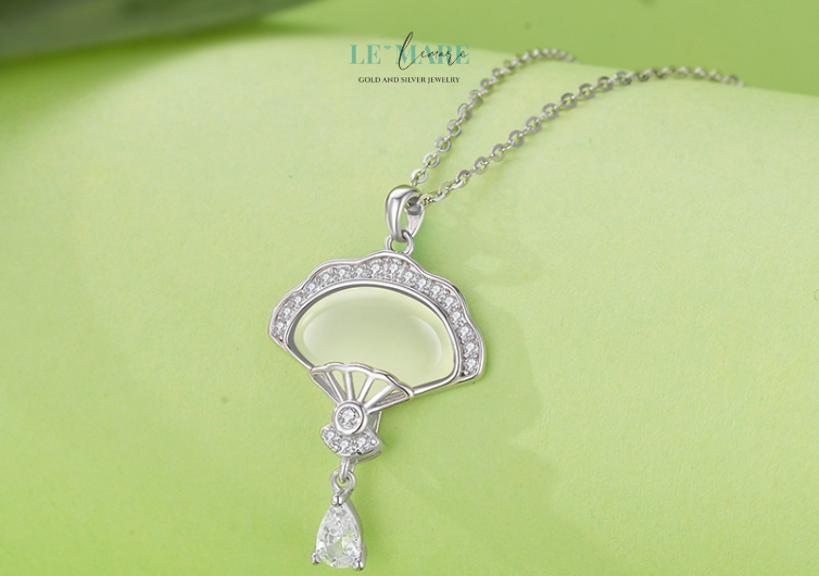 Lấy cảm hứng từ từ “sensu” – quạt giấy truyền thống của Nhật, kết hợp với hậu tố “-elle” mang âm hưởng Pháp nữ tính, nhẹ nhàng, Senselle là biểu tượng của vẻ đẹp vừa phương Đông kín đáo, vừa phương Tây kiêu kỳ. Như một nàng thơ khoác tấm áo lụa, chiếc dây chuyền nữ này không cần phải phô trương – mà vẫn khiến người đối diện không thể rời mắt.Ở trung tâm là viên ngọc bích màu lục sâu, như chiếc lá non giữa tiết xuân, được ôm ấp bởi thiết kế mô phỏng hình chiếc quạt giấy đang xoè nửa – một phần giấu mình, một phần hé lộ, đầy duyên dáng và gợi cảm.