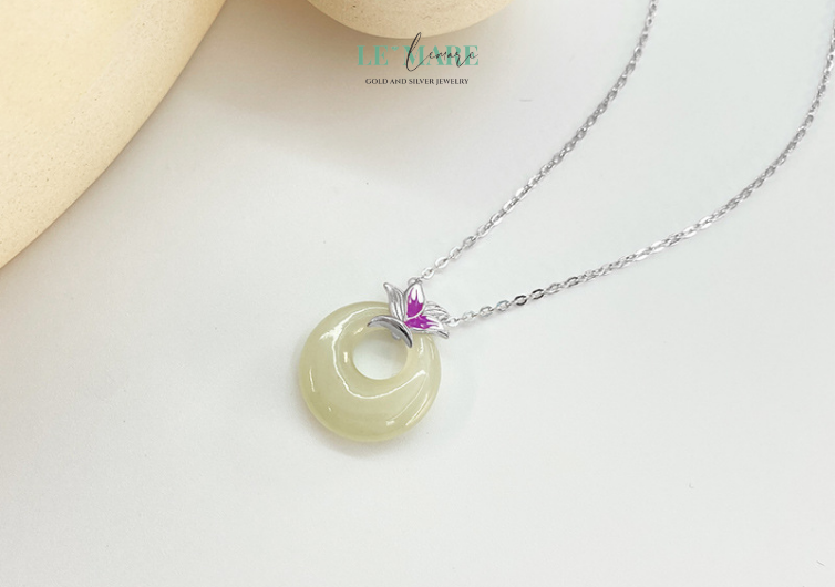 Dây chuyền "Tử Yên" không chỉ là món trang sức, mà còn là lời thủ thỉ nhẹ nhàng của tâm hồn – tĩnh tại mà sâu sắc, mềm mại nhưng không kém phần vững chãi. Viên ngọc bích xanh ngọc được đặt giữa trung tâm, được bao bọc bởi họa tiết ánh tím ẩn hiện như cánh hoa chớm nở, gợi hình ảnh yên bình của một buổi hoàng hôn tĩnh lặng nơi vườn xưa.