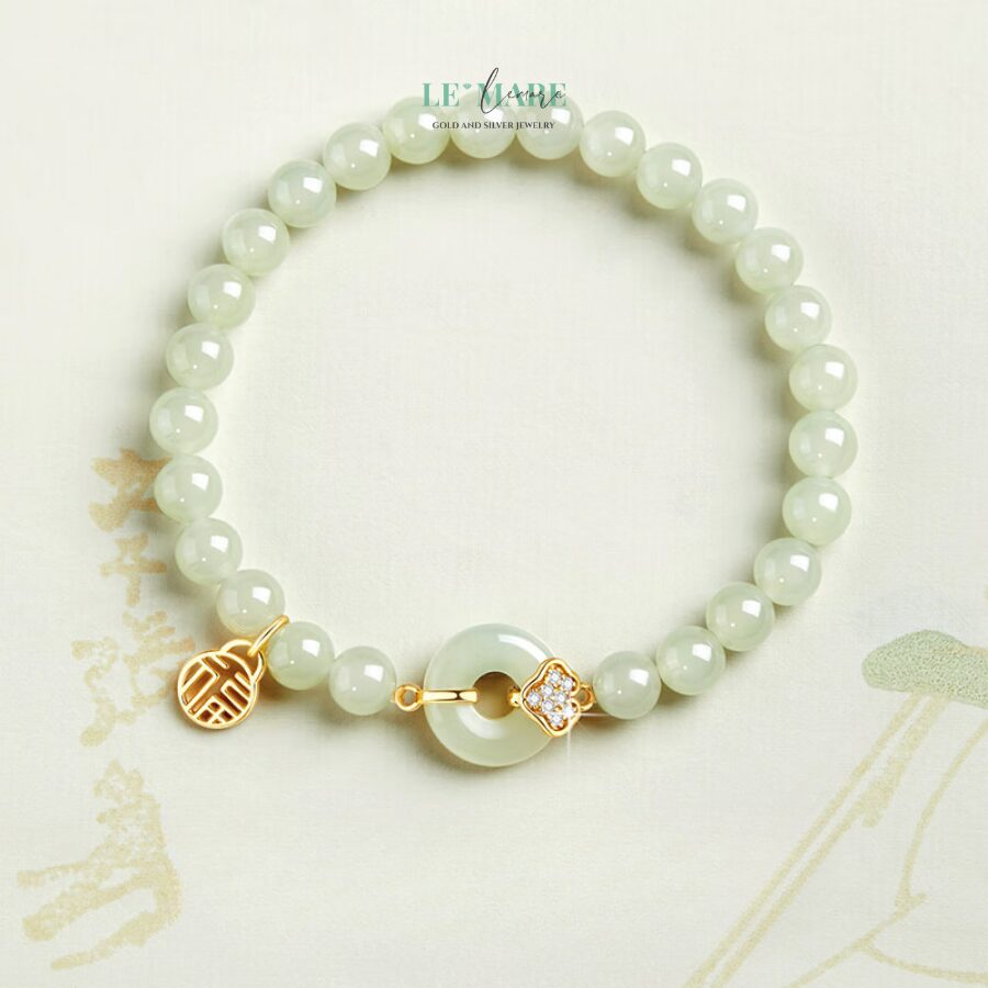 Trường An Ngọc – Dấu Ấn Bình Yên Giữa Đời Thường BNVT34 Ngọc bích, từ bao đời nay, luôn được mệnh danh là “đá của trời”, mang trong mình vẻ đẹp tĩnh lặng, an hòa và linh thiêng. Trong thiết kế Trường An Ngọc, từng hạt ngọc được tuyển chọn kỹ lưỡng, giữ nguyên sắc xanh đặc trưng – xanh không quá rực rỡ, nhưng đủ khiến người ta muốn dừng lại, ngắm nhìn, và lắng nghe một bản giao hưởng trầm mặc của thời gian.Sự phối hợp tinh tế giữa ngọc bích và bạc trắng tạo nên một vòng tay bạc nữ không chỉ là trang sức mà còn là một biểu tượng. Biểu tượng của sự bền bỉ, thủy chung và tĩnh tại trong tâm hồn người phụ nữ hiện đại.